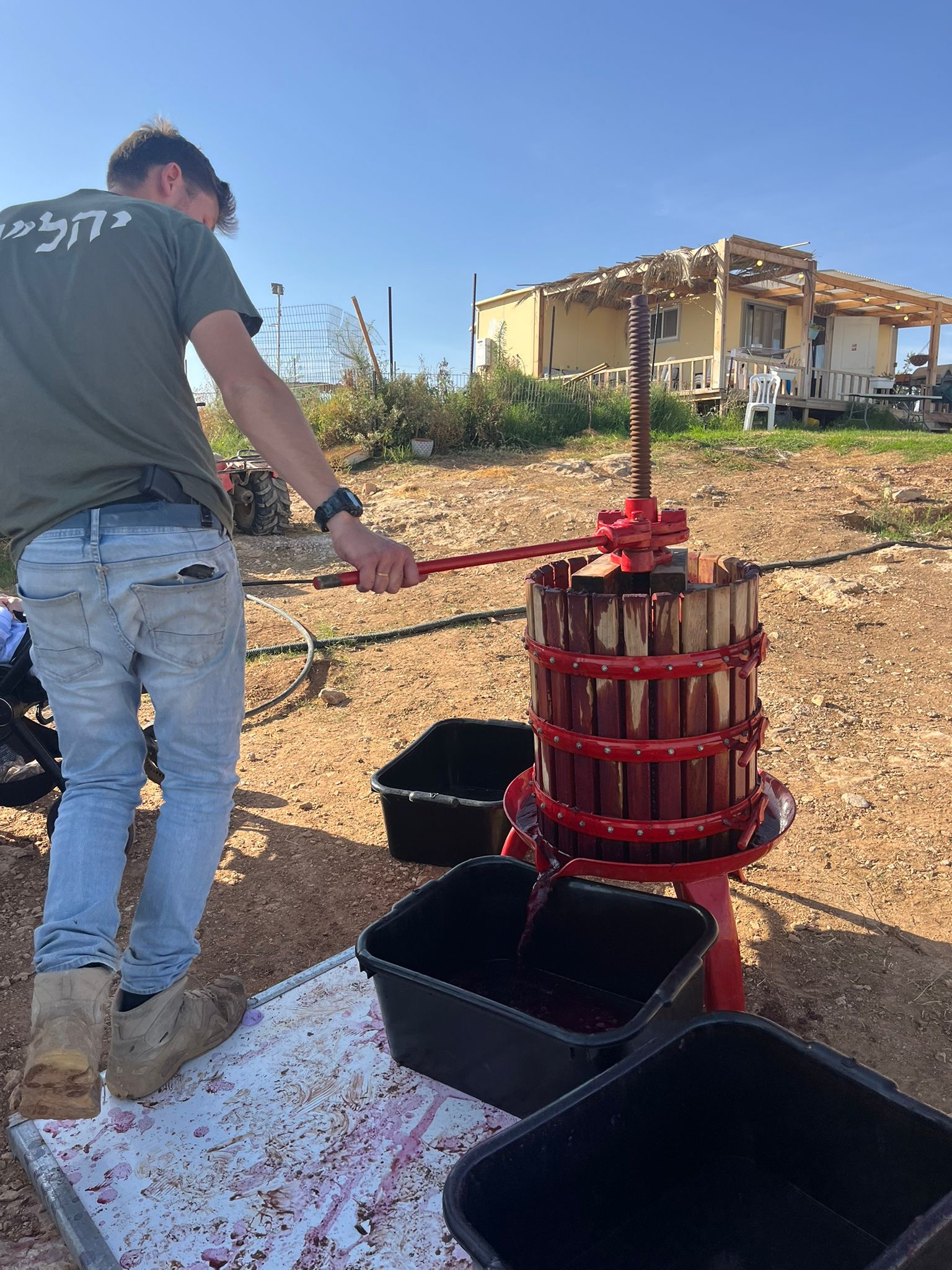 Veteran working with wine press and agricultural equipment